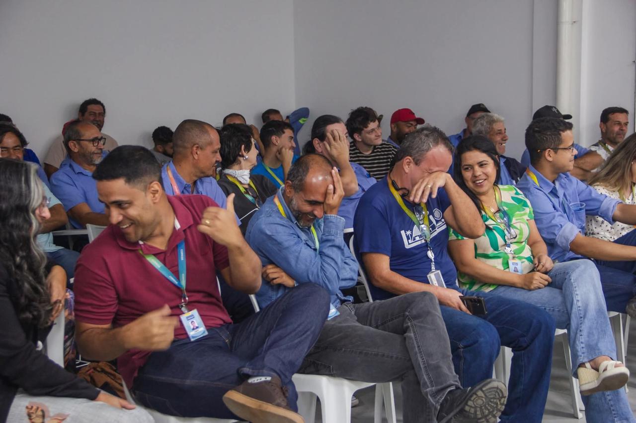 Colaboradores rindo durante apresentação corporativa